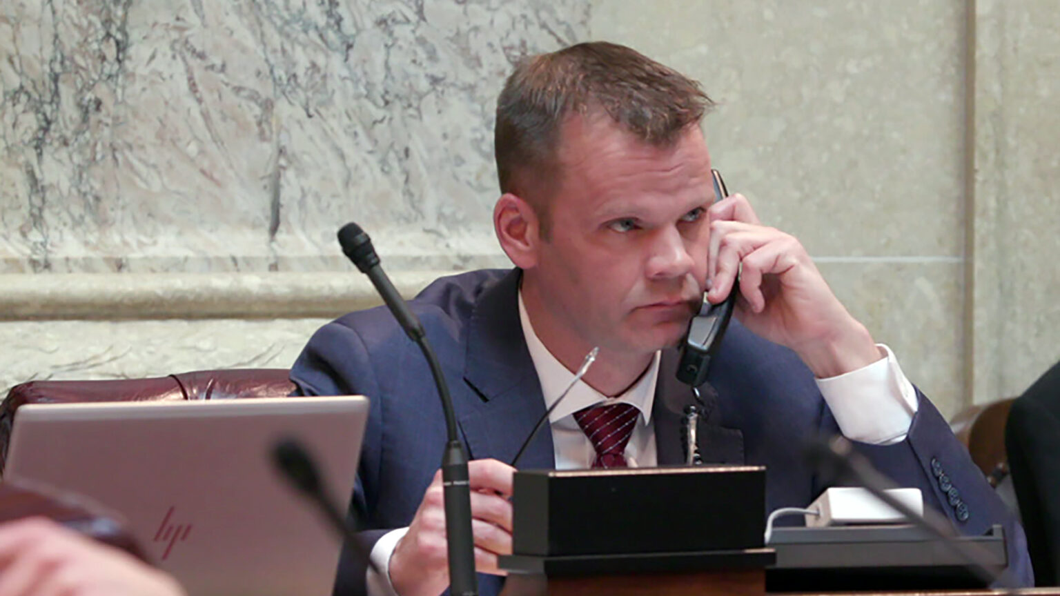 Devin LeMahieu sits at his desk and speaks on a phone in the chambers of the Wisconsin Senate.