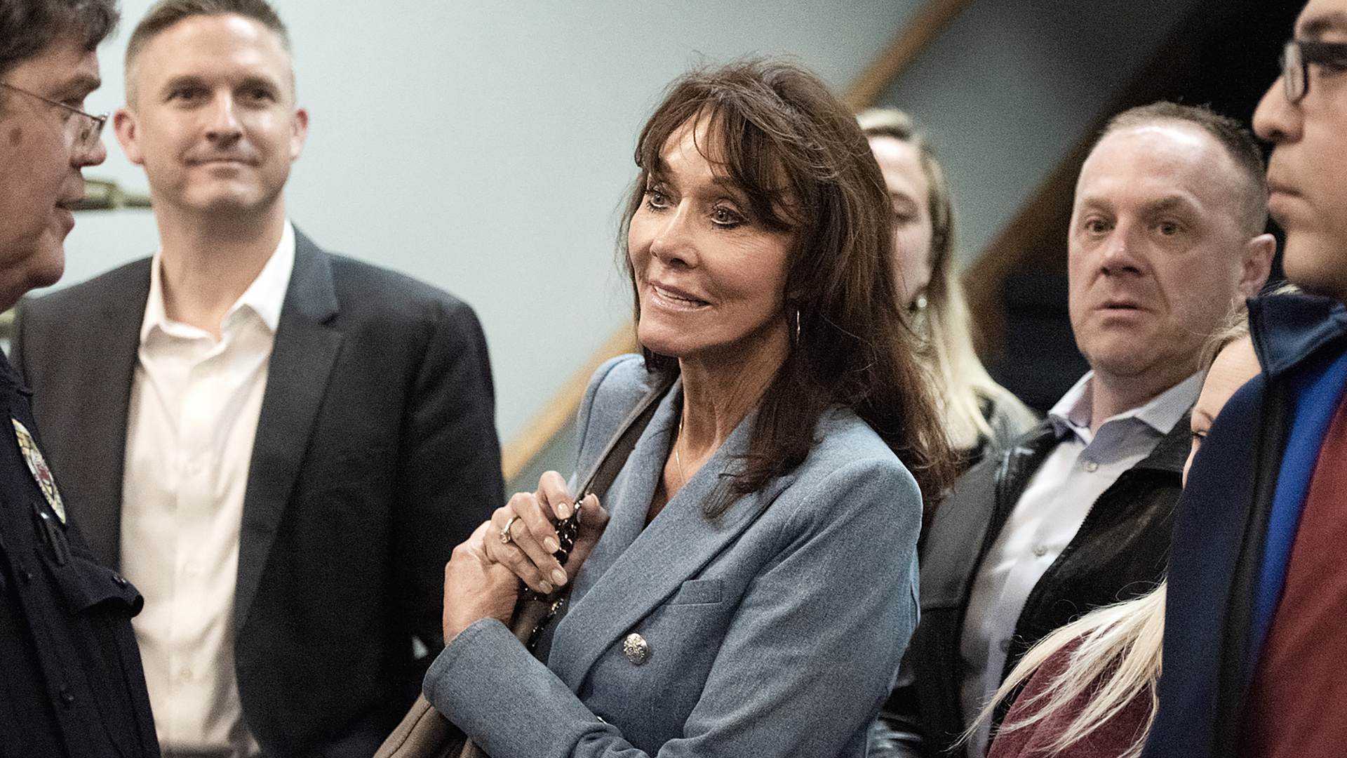 Diane Hendricks stands and speaks to another person, with more people standing to the side and in the background.