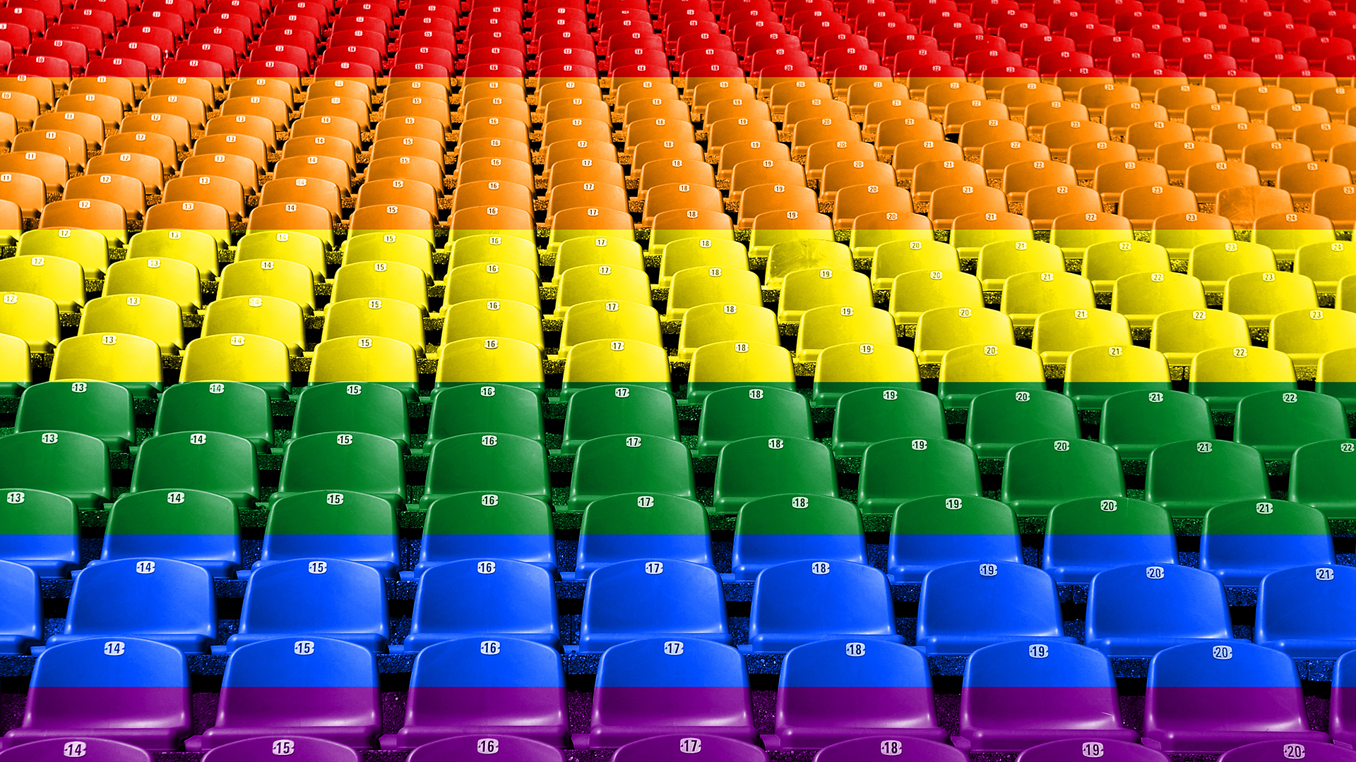 Rows of empty stadium seats in the colors of the rainbow Pride flag.