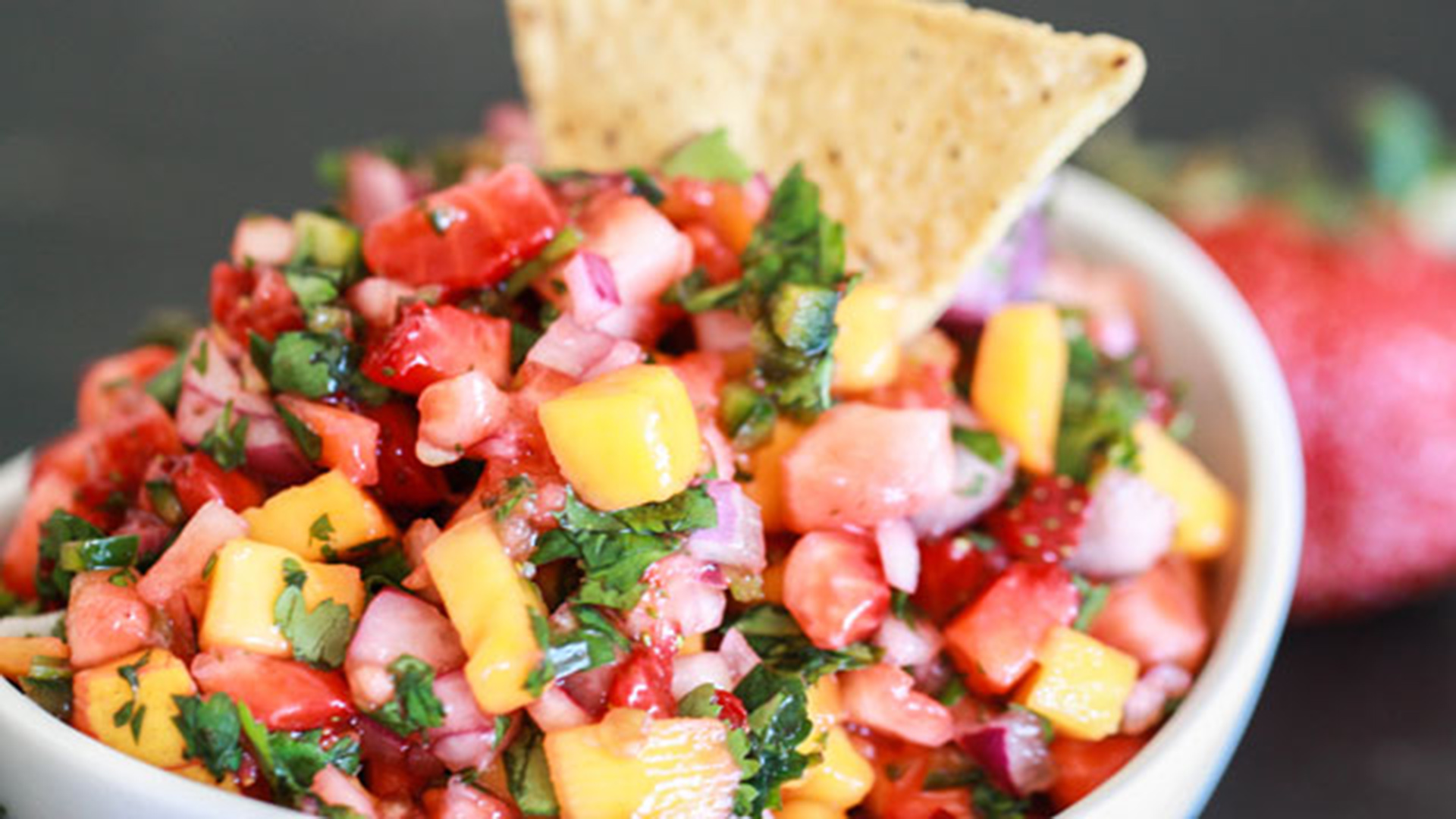 Tortilla chip dipped into salsa.