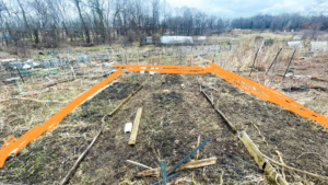 A community garden plot in very early spring showing its edges and boundaries, and soil.