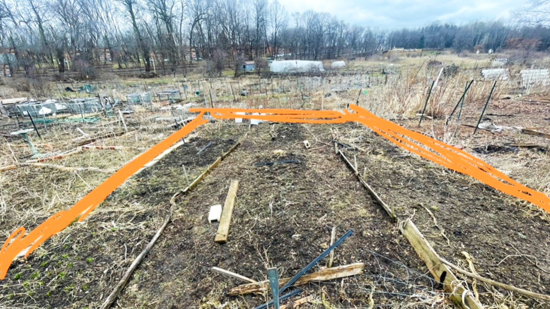 A community garden plot in very early spring showing its edges and boundaries, and soil.