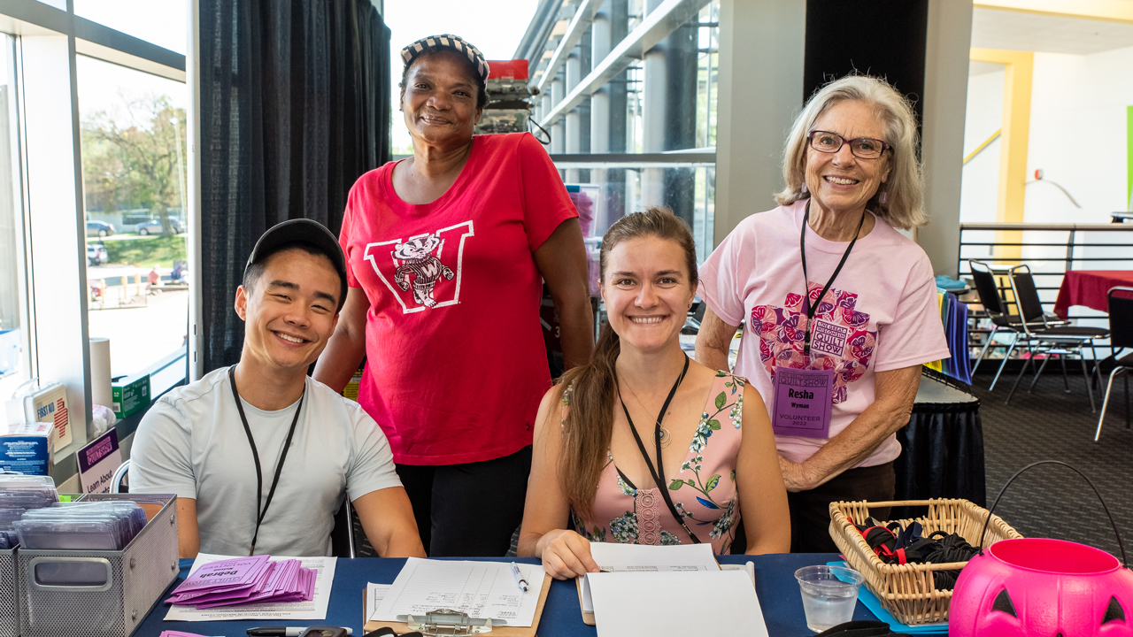A group of volunteers smile behind a table
