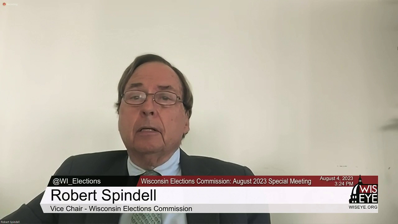 A video still image shows Robert Spindell siting in a room and speaking into a computer camera, with a video graphic on the bottom of the image noting his name, his title as vice chair of the Wisconsin Elections Commission and a label that the group is holding a August 2023 Special Meeting.