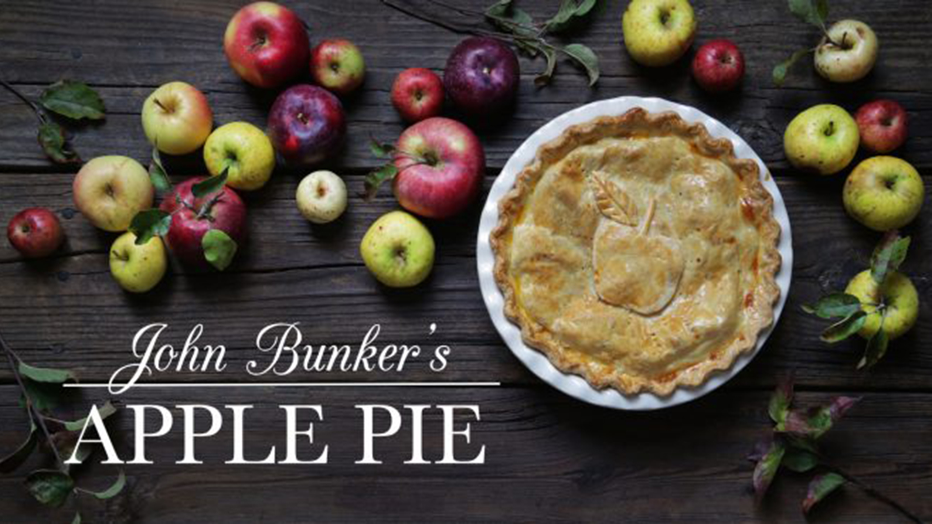 Apple pie on a table surrounded by apples.