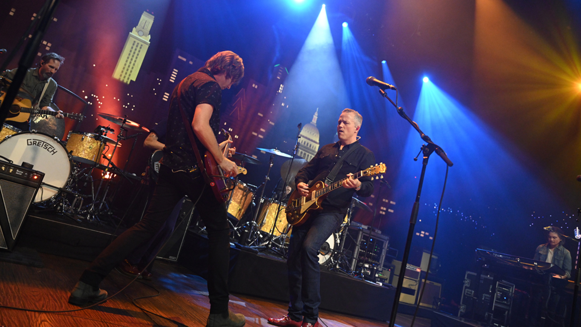 Two guitar players perform on stage.