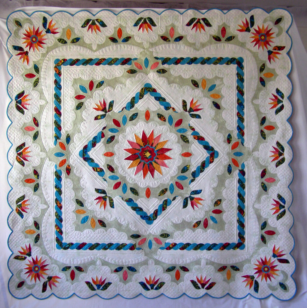 A floral medallion quilt of greens, reds and blues