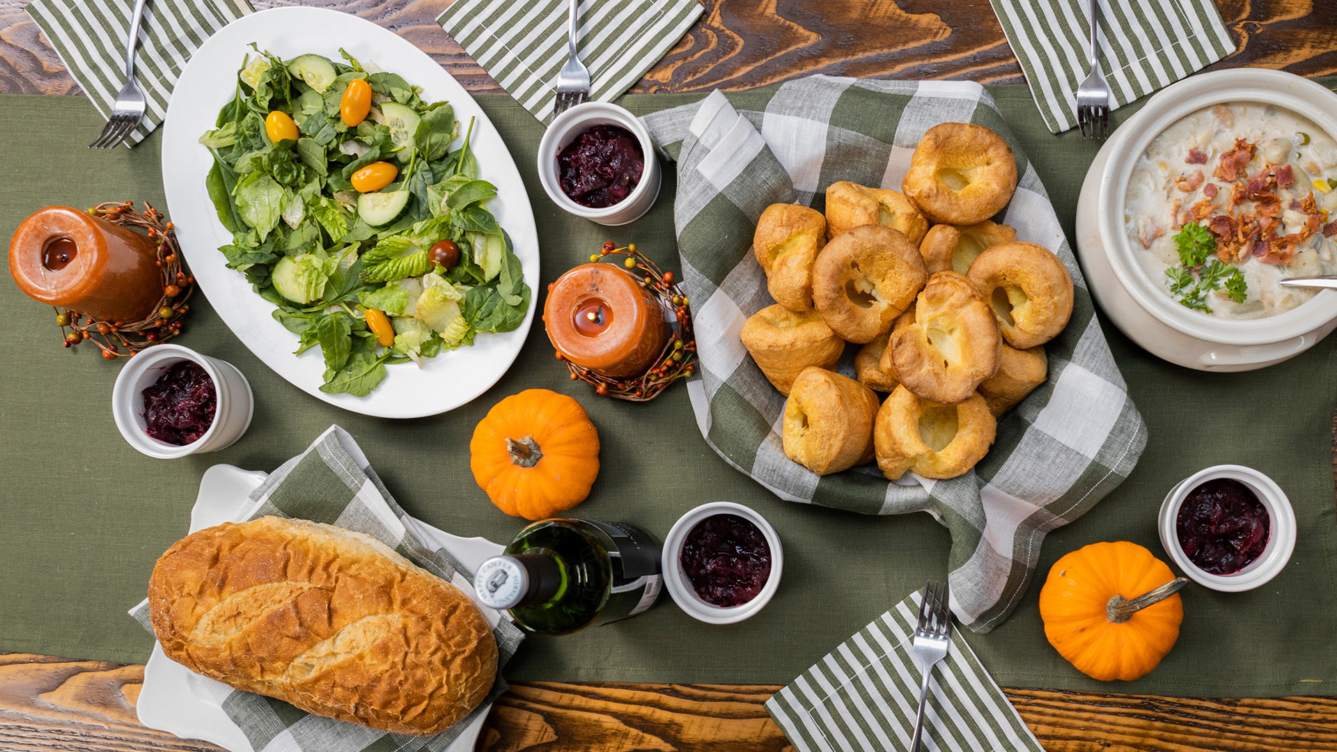 A table is set with platters of salad, croissants and bread.