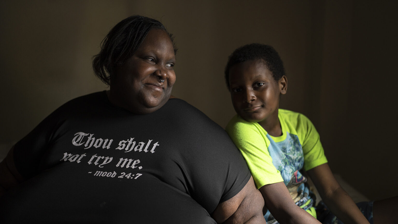 Deanna Branch looks at Aidan Branch while smiling as both sit in a dark room.