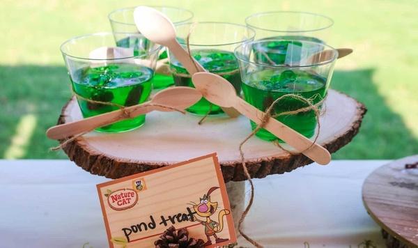 A serving tray with cups of green jello.