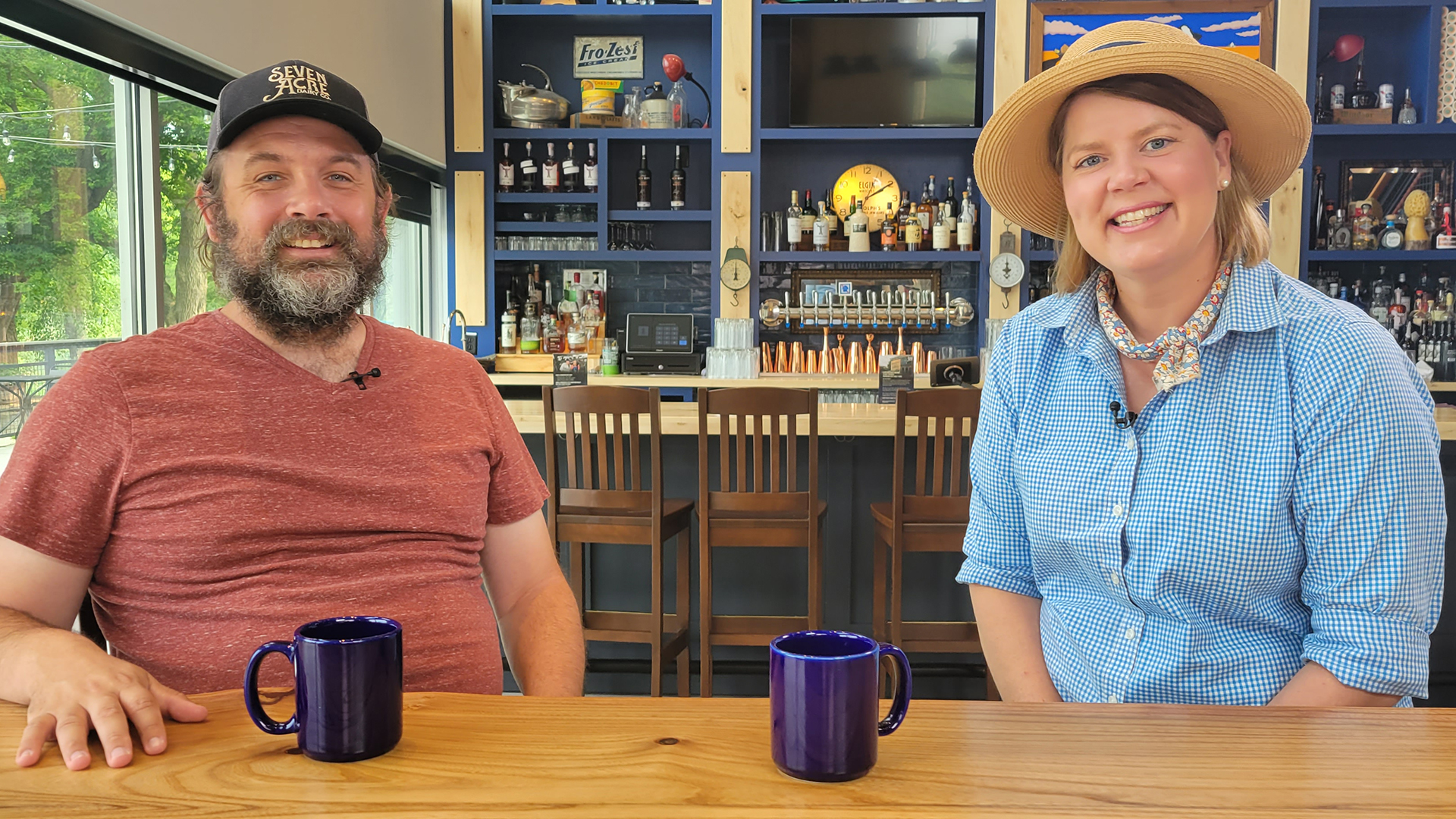 Host Inga Witscher sits with Seven Acre Dairy Company owner Nic Mink inside a cafe. 