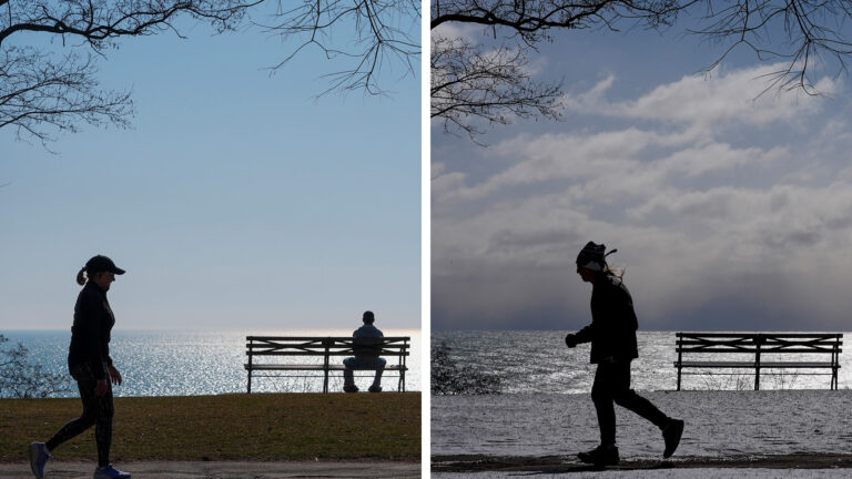 Two side-by-side photos show the same setting of a park bench on a lawn next to a leafless tree, with a sidewalk in the foreground and water stretching to the horizon in the background, with the left photo showing a person walking and another seated under a cloudless sky and with bare ground, and the right photo showing a person running under a cloudy sky and snow-covered ground.