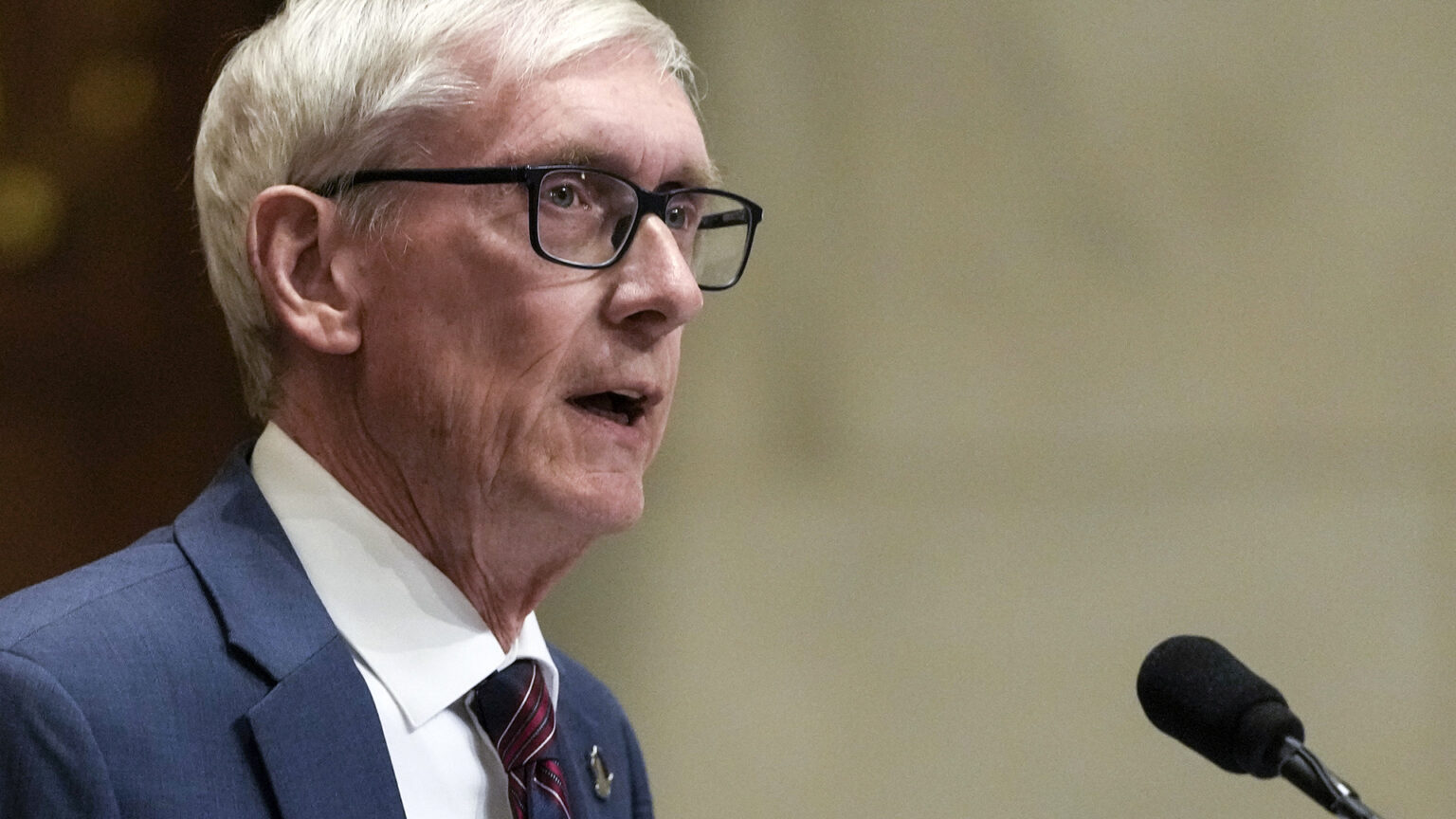 Tony Evers speaks into a microphone.