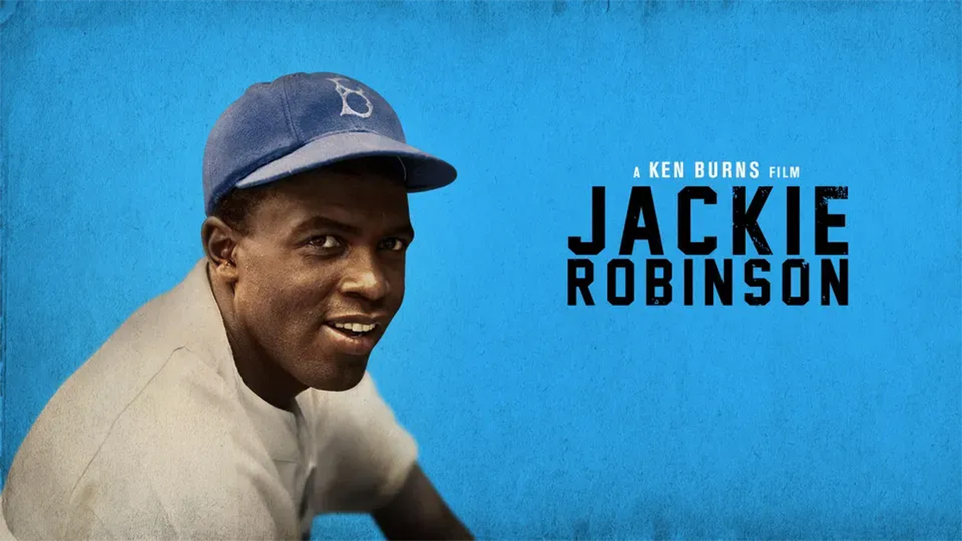 Jackie Robinson wearing a Brooklyn Dodgers baseball uniform and 'B' hat with title of film on right-hand side.