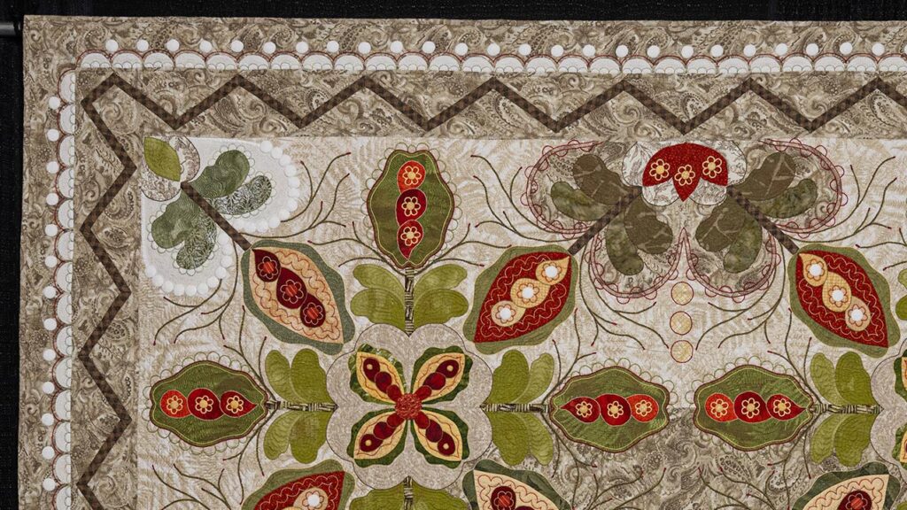 Upper left-hand corner of "The Crossing," a traditional, warm-toned quilt embellished with white circles throughout.