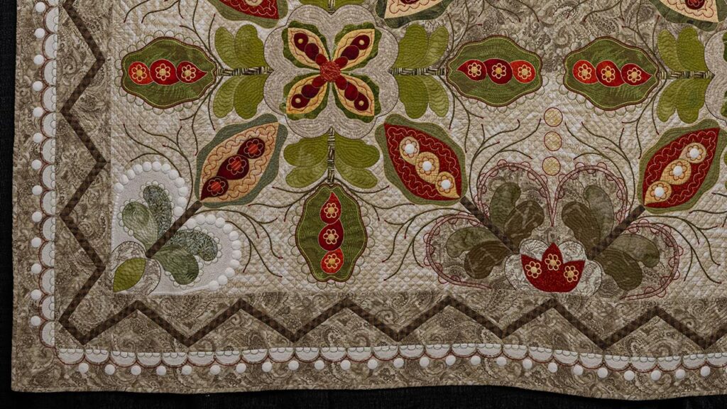 Lower left-hand corner of "The Crossing," a traditional, warm-toned quilt embellished with white circles throughout.