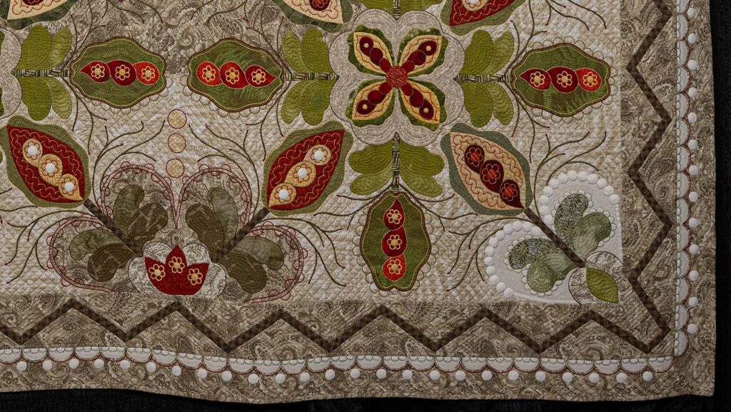 Lower right-hand corner of "The Crossing," a traditional, warm-toned quilt embellished with white circles throughout.