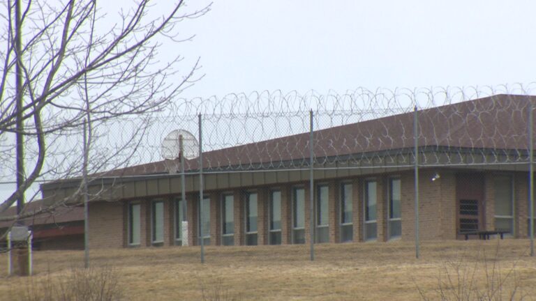 The exterior of Lincoln Hills youth prison with a barbed wire fence in front.