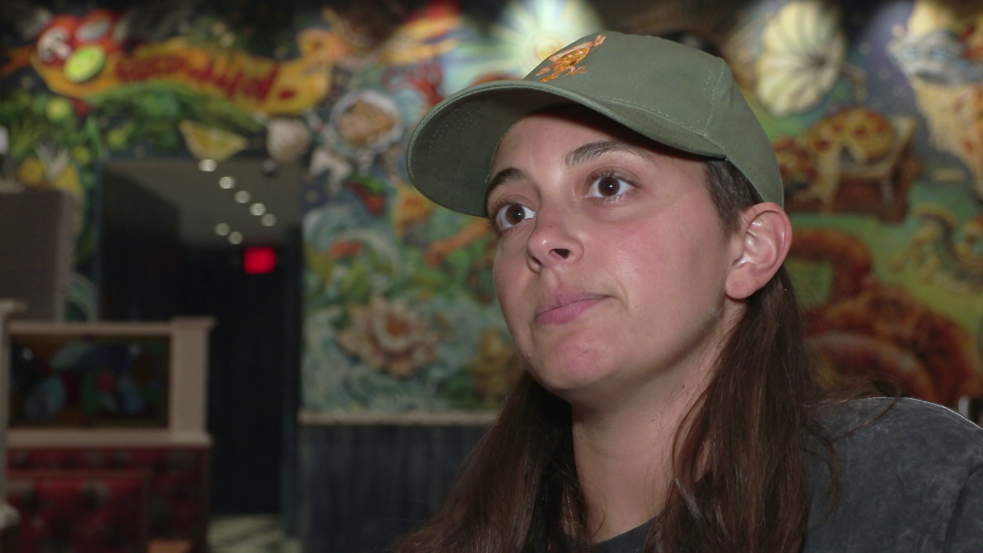 Anne Marie Cieri speaks in a room with graphic art on the wall in the background.