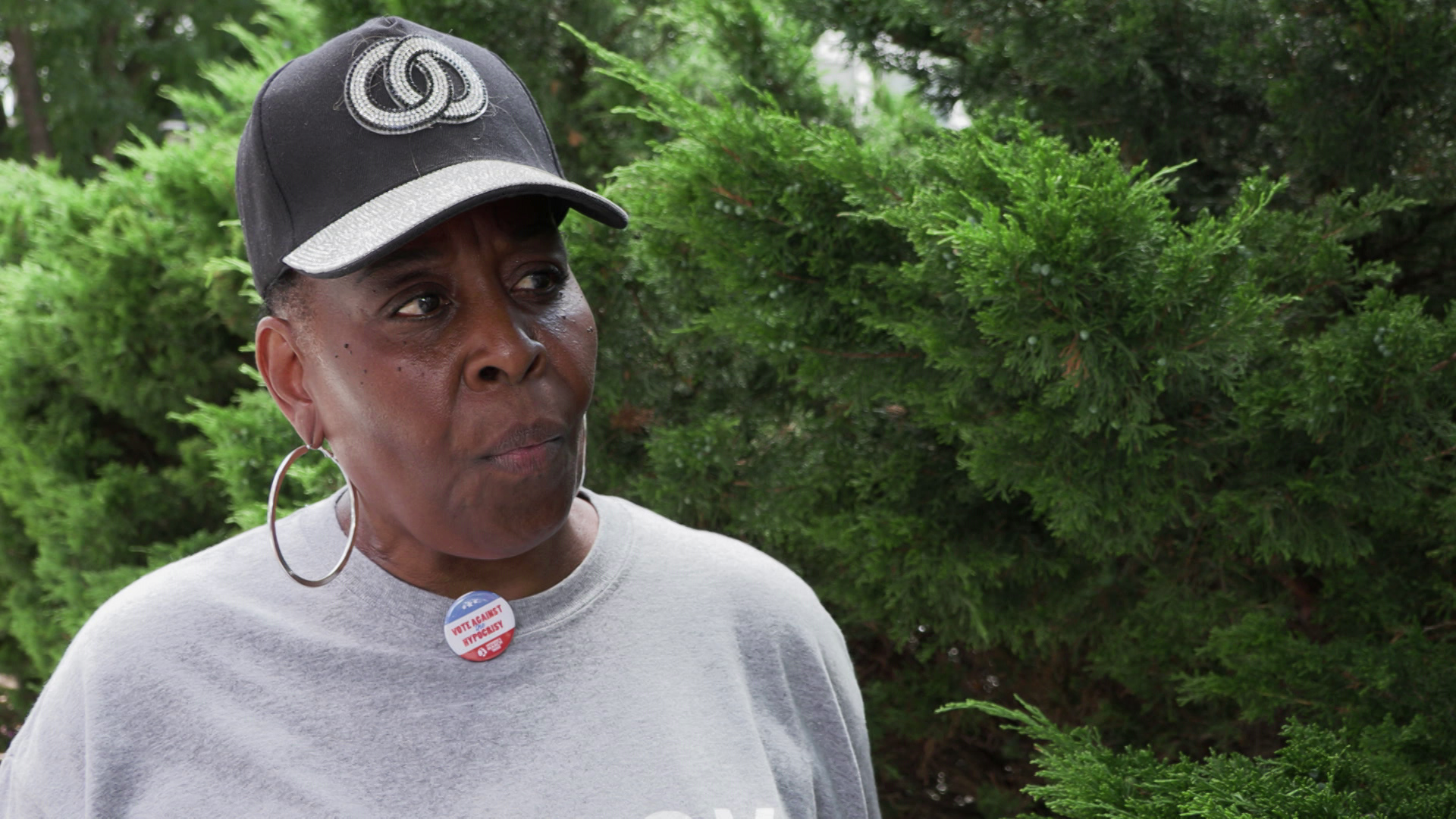 Jackie Clark speaks while standing outside with trees in the background.