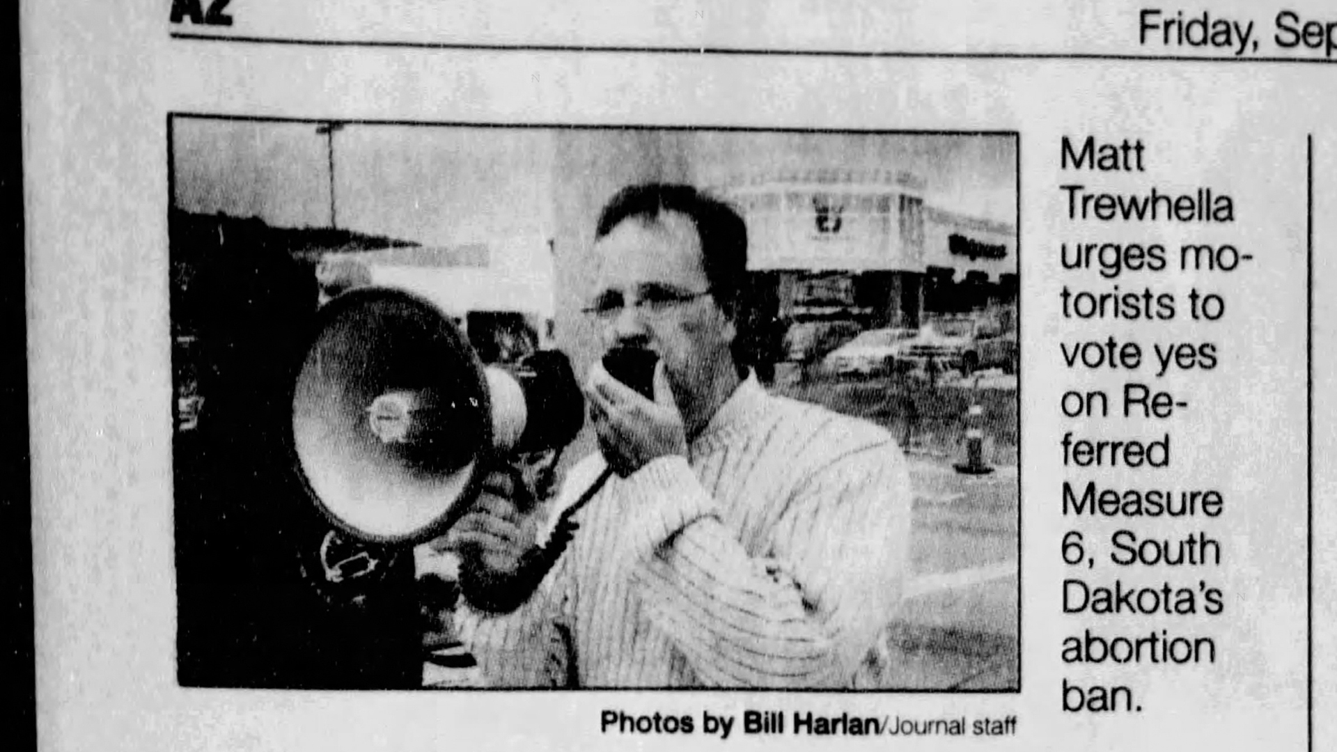 A clip from a newspaper shows a black-and-white photo of Matthew Trewhella speaking into a microphone attached to a megaphone, with an adjacent caption reading "Matt Trewhella urges motorists to vote yes on Referred Measure 6, South Dakota's abortion ban."