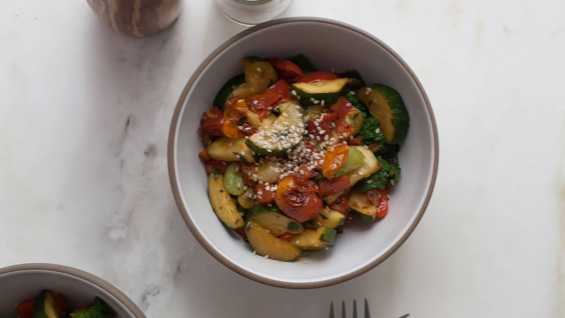 Bowl of succotash with forks nearby