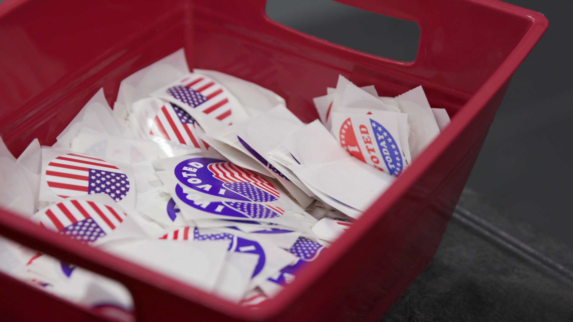 A bucket holds various stickers with a U.S. flag graphic with the words 'I Voted.'