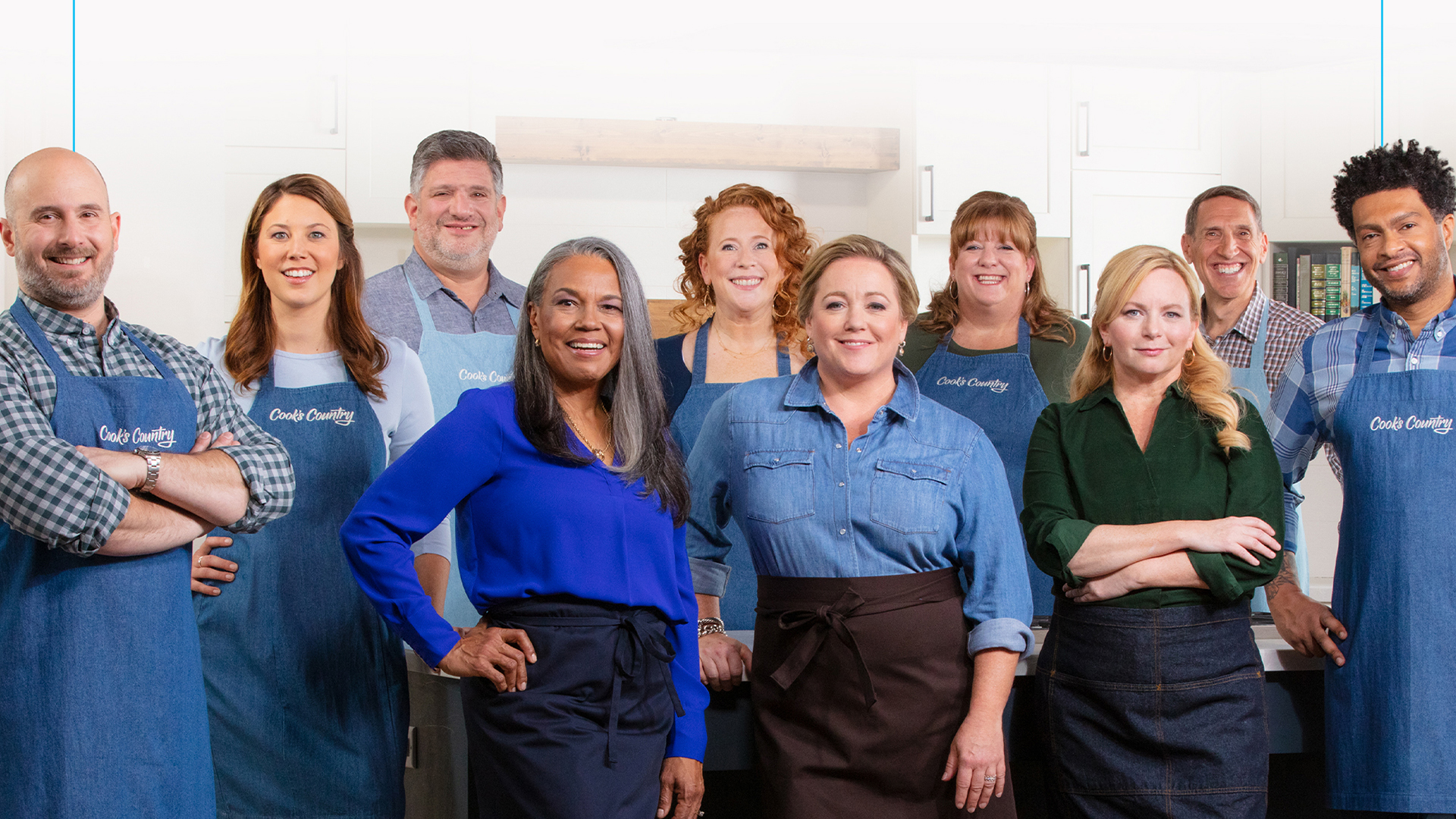 The cast of Cook's Country stands together and smiles at the camera.