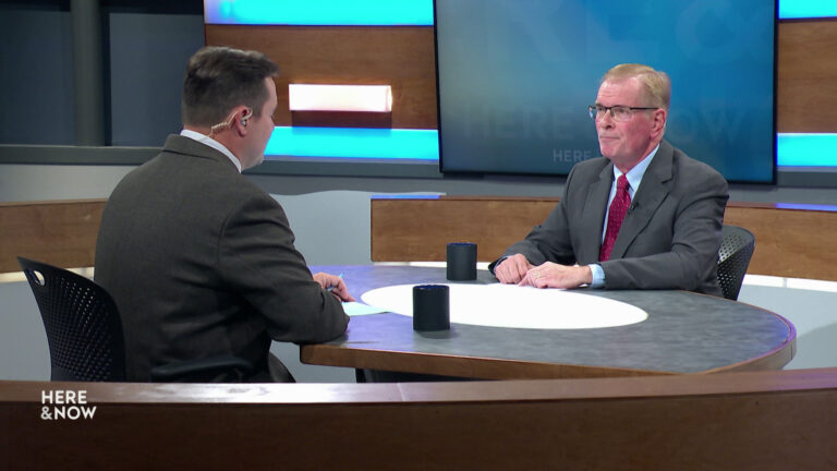 Zac Schultz and Dan Rossmiller sit facing each other on the Here & Now set.