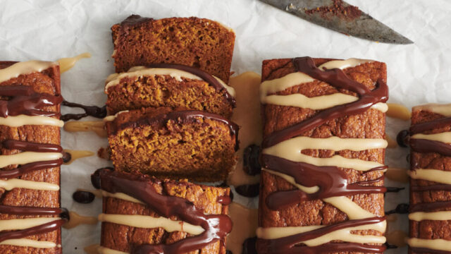 A glamor shot of pumpkin bread drizzled with chocolate and white icing.