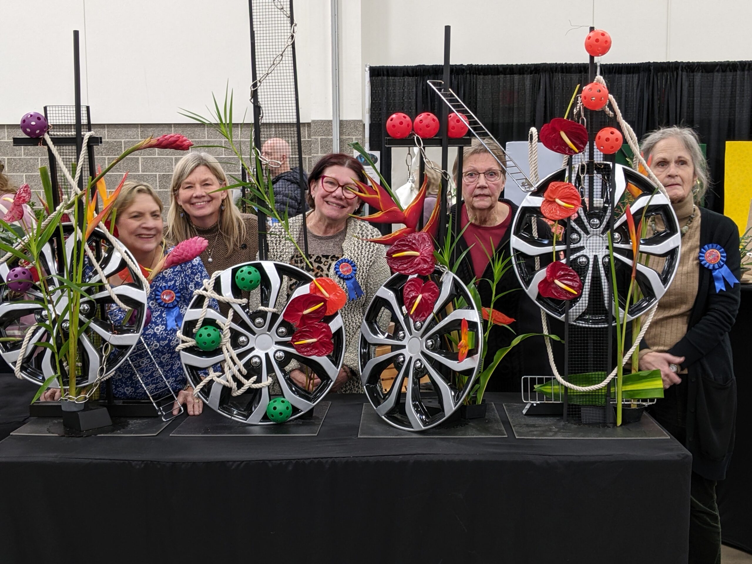 Five participants standing behind a table with a black cloth to present their exhibits in the Designer Challenge of the 2024 Garden and Landscape Expo.