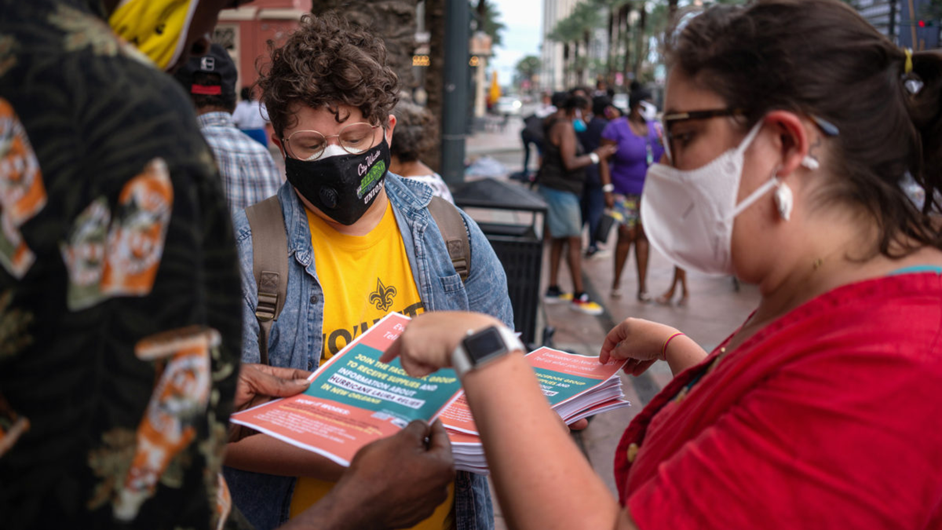 Two activists hand out fliers on an urban street corner