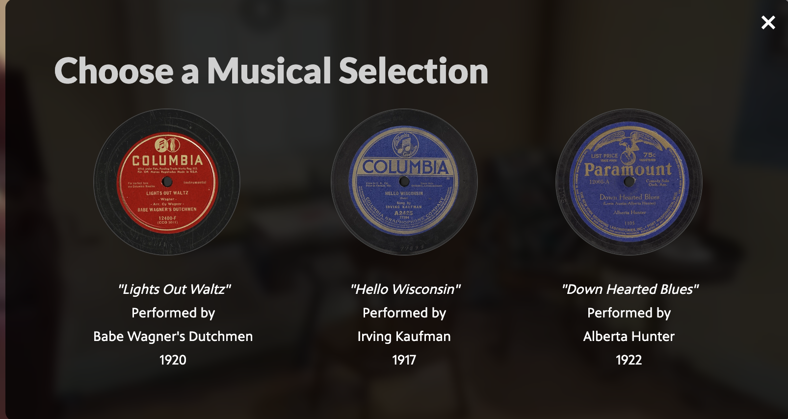 Music selection pop up window for the Illuminating Cana Island interactive experience with 'Choose a Musical selection' written in white on the top with three selections below: "Lights Out Waltz" performed by Babe Wagner's Dutchmen, 1920, on the left. "Hello Wisconsin" performed by Irving Kaufman 1917 in the middle. "Down Hearted Blues" performed by Alberta Hunter 1922 on the right.