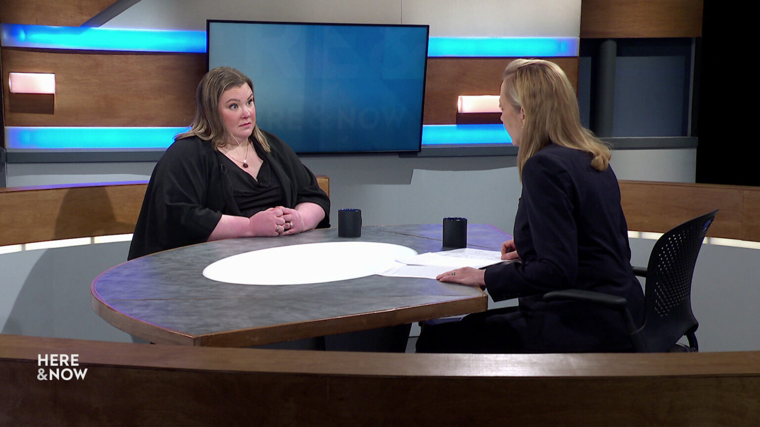 Erin Neill and Frederica Freyberg sit facing each other on the Here & Now set.