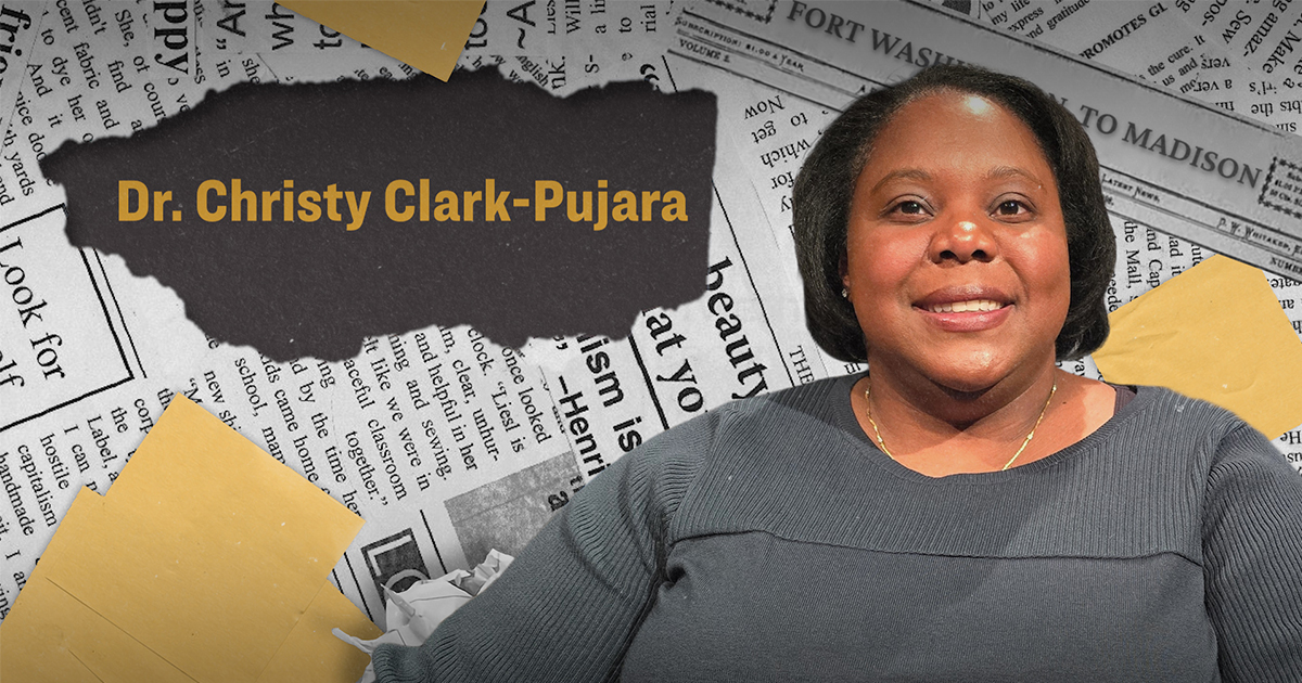 Smiling woman with short hair, wearing a gray sweater, is in front of a backdrop of overlapping newspapers with "Dr. Christy Clark-Pujara" text. Tone is professional.