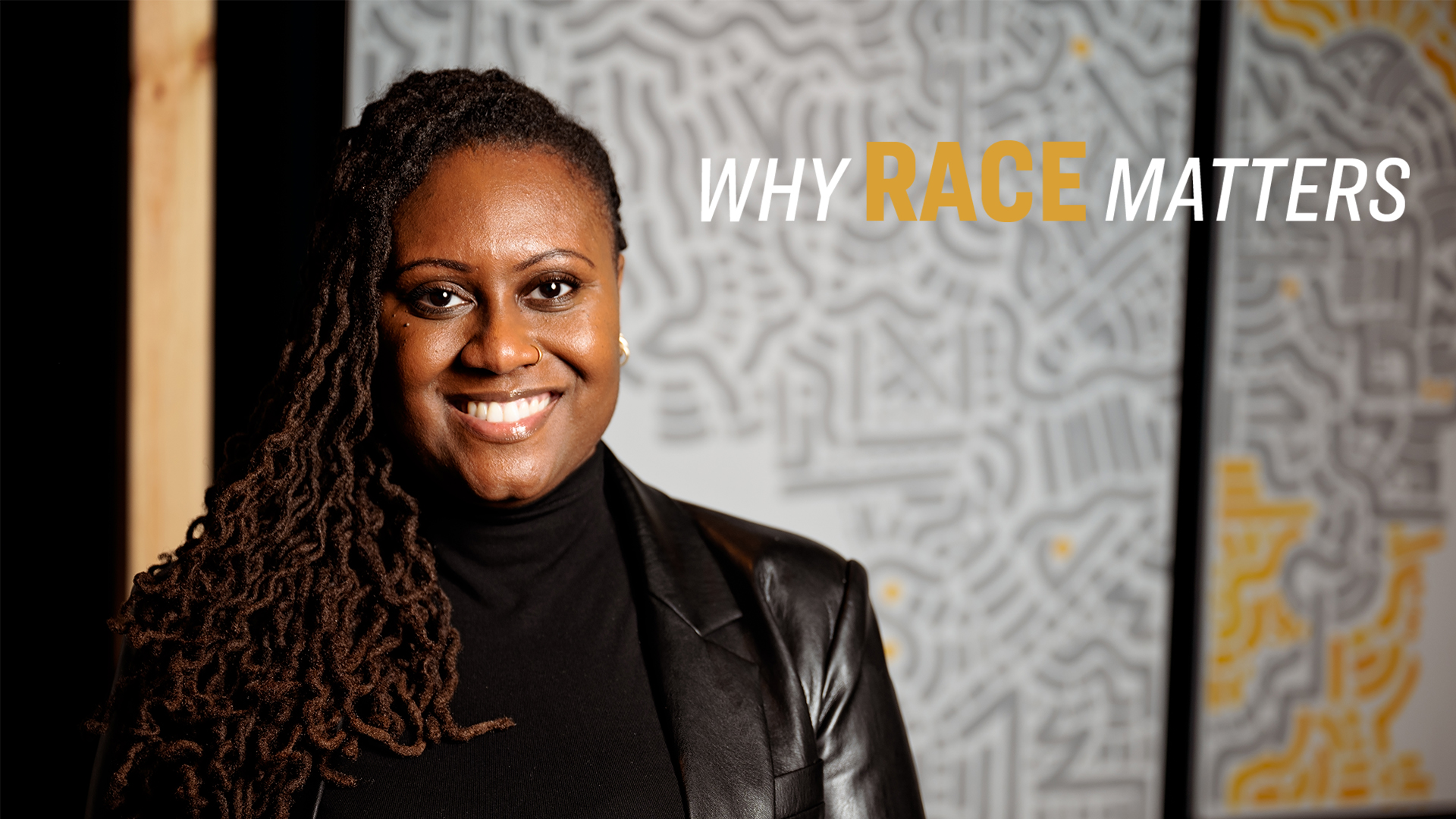 Smiling person with long hair, wearing a black jacket, stands before an abstract, patterned background. Text reads "Why Race Matters."