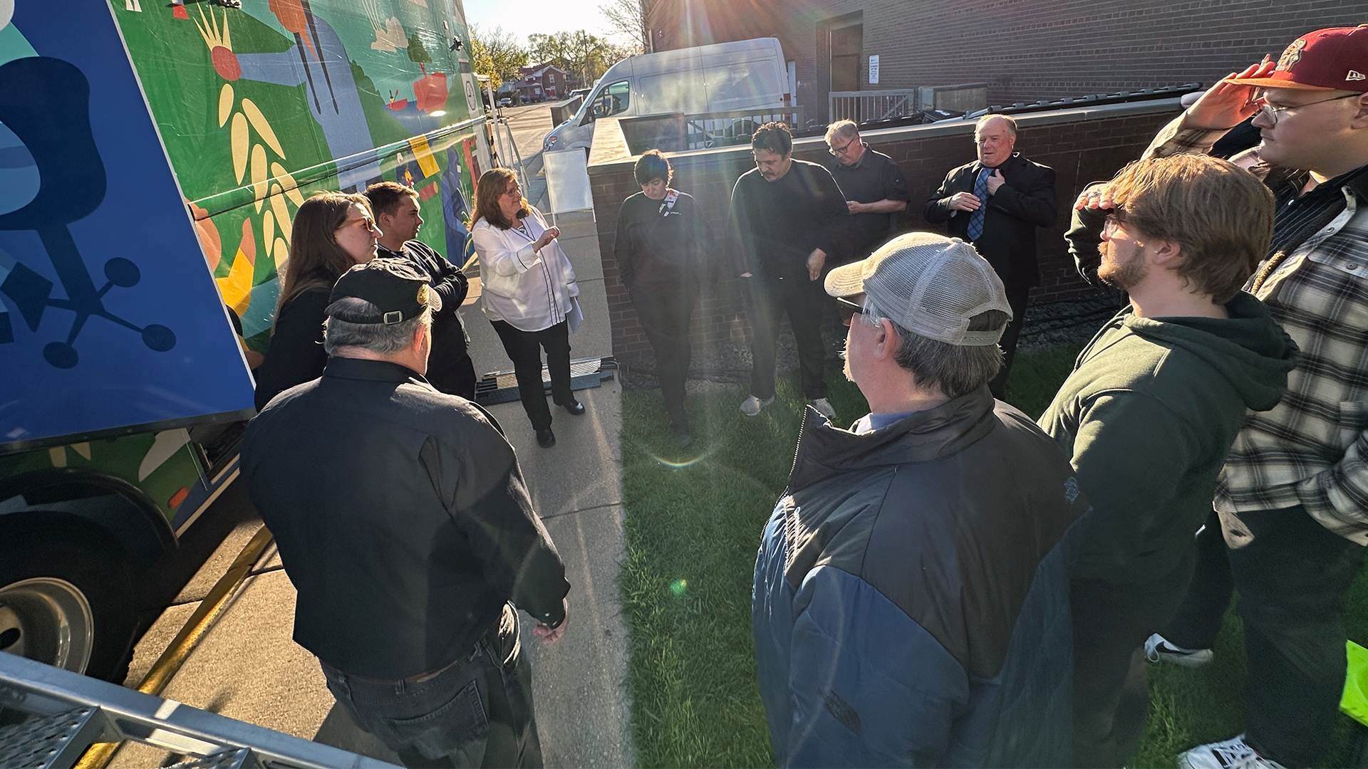 Several individuals on the PBS Wisconsin crew standing outside of the production truck at the Viterbo University Fine Arts Center, chatting and preparing to broadcast the La Crosse Symphony Orchestra’s performance of “Midnight in Paris.”