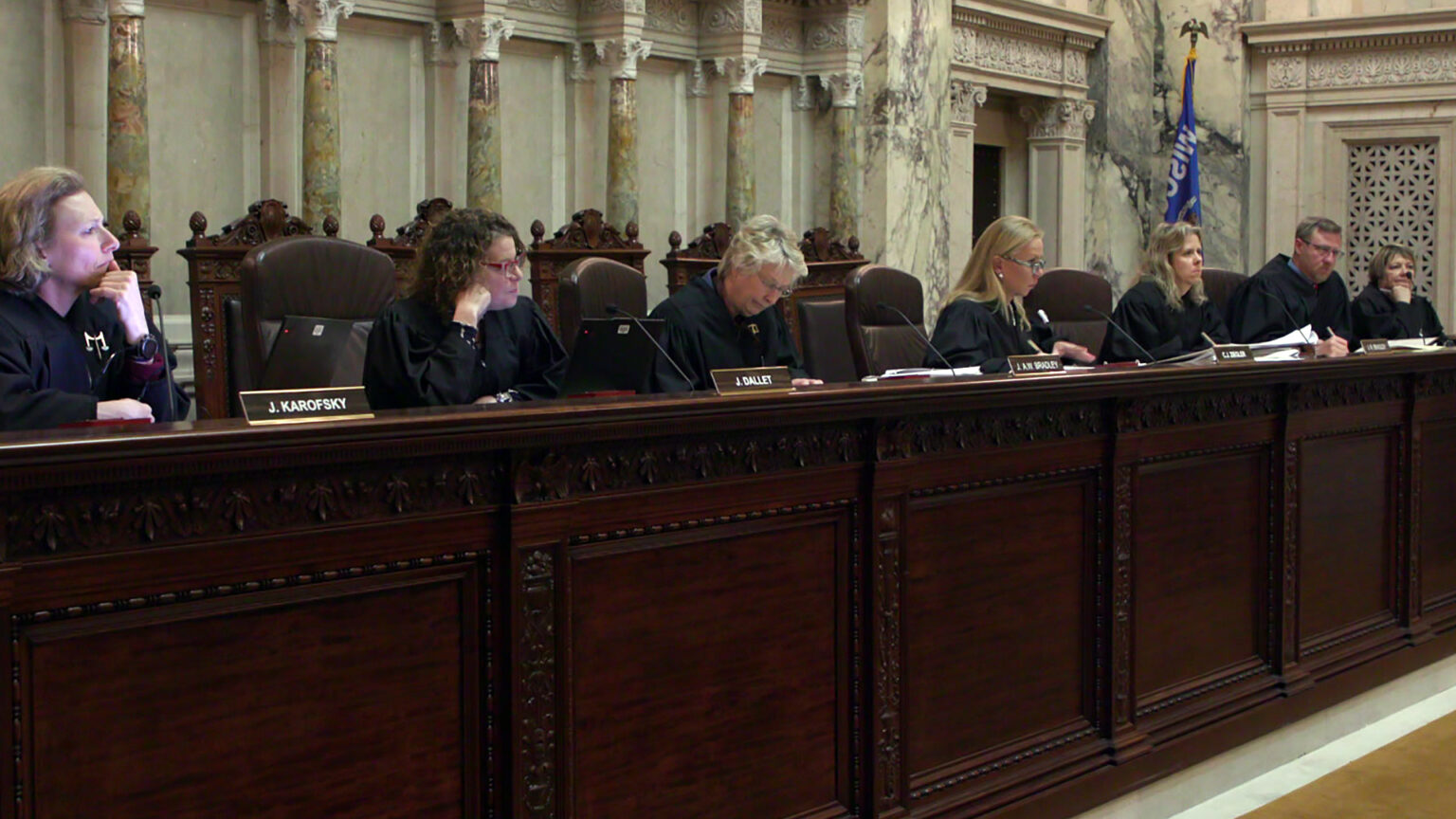 From left to right, Jill Karofsky, Rebecca Dallet, Ann Walsh Bradley, Annette Ziegler, Rebecca Bradley, Brian Hagedorn and Janet Protasiewicz sit in high-backed leather chairs at a judicial dais, with another row of high-backed wood and leather chairs behind them, in a room with marble masonry and a Wisconsin flag. From left to right, Jill Karofsky, Rebecca Dallet, Ann Walsh Bradley, Annette Ziegler, Rebecca Bradley, Brian Hagedorn and Janet Protasiewicz sit in high-backed leather chairs at a judicial dais, with another row of high-backed wood and leather chairs behind them, in a room with marble masonry and a Wisconsin flag.