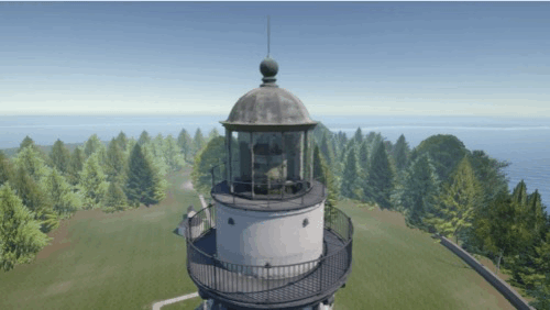 Top of a white lighthouse with observation deck overlooking trees and water.