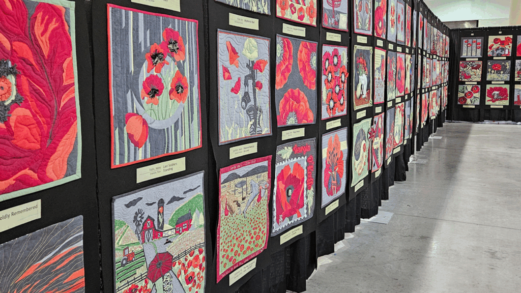 A gallery of brightly-colored, coordinating mini quilts, each with poppy flowers featured in the design.