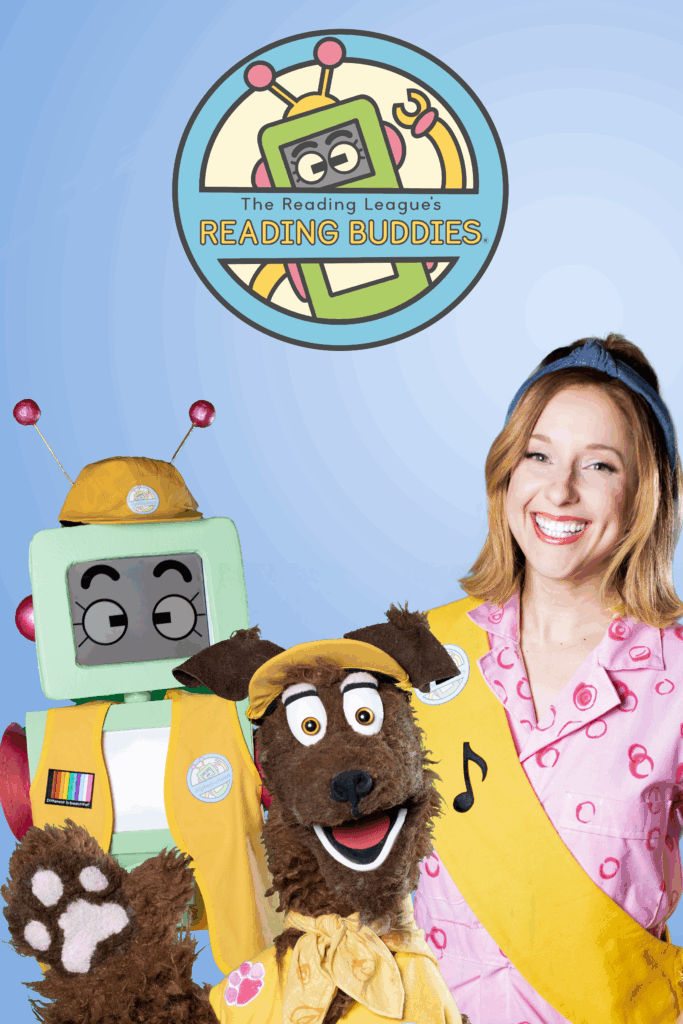 A robot puppet and a dog puppet pose next to a woman smiling at the camera
