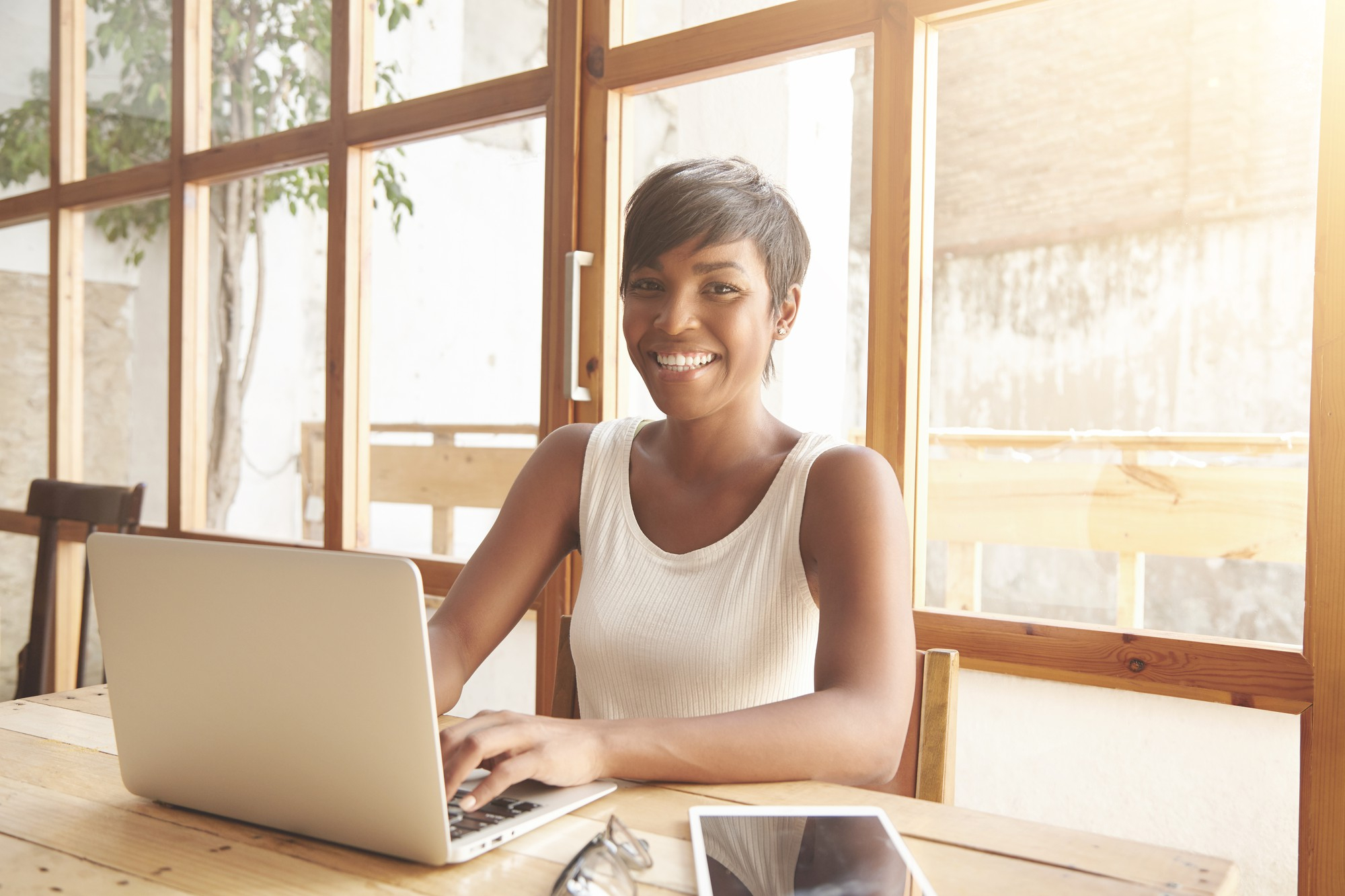 Smiling woman typing on laptop.