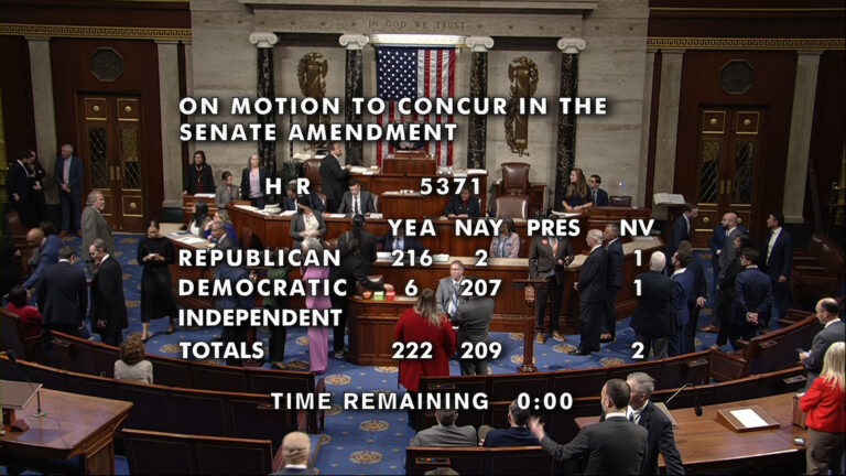 An overhead view of the U.S. House of Representatives chamber, including its legislative dais with a U.S. flag behind the Speaker's podium and curved rows of desks facing the rear wall with dais and two sets of double doors, shows multiple people standing on the floor and seated in benches, with overlaid text reading On Motion to Concur in the Senate Amendment and vote totals for Yea, Nay, Pres and NV for Republican, Democratic and Independent members.