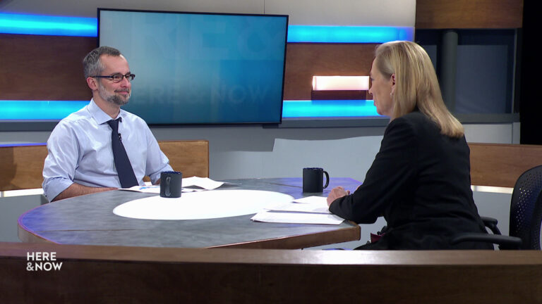 Mark Sommerhauser and Frederica Freyberg sit facing each other on the Here & Now set.