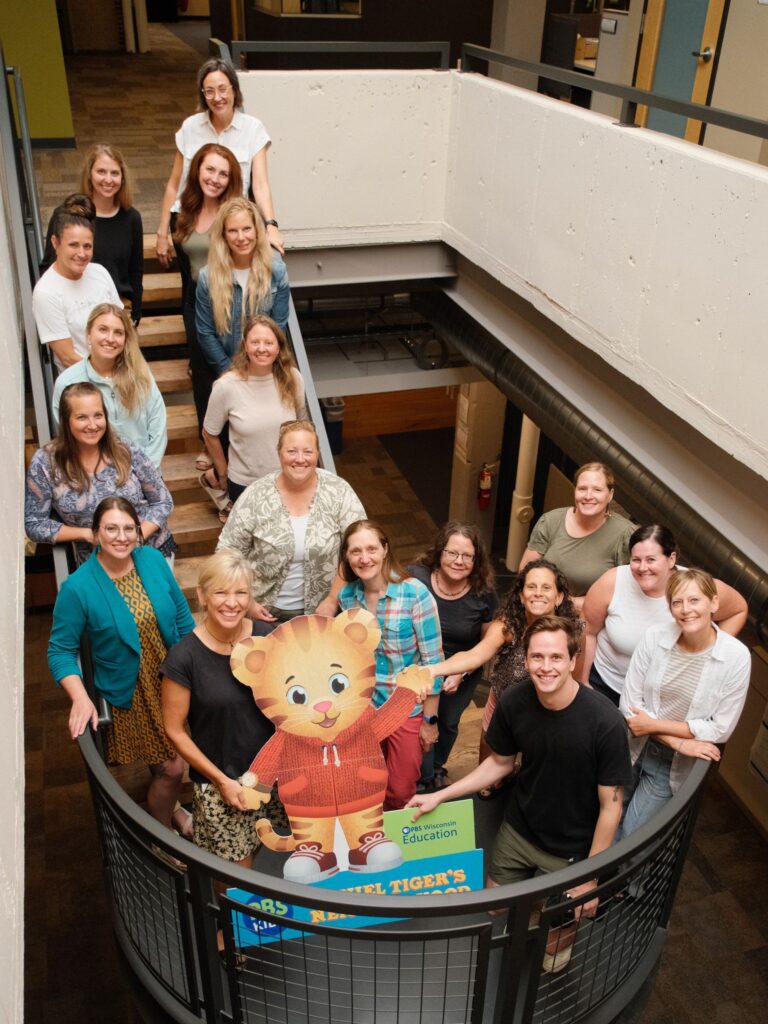 A small group of people stand on a staircase posing for a photo