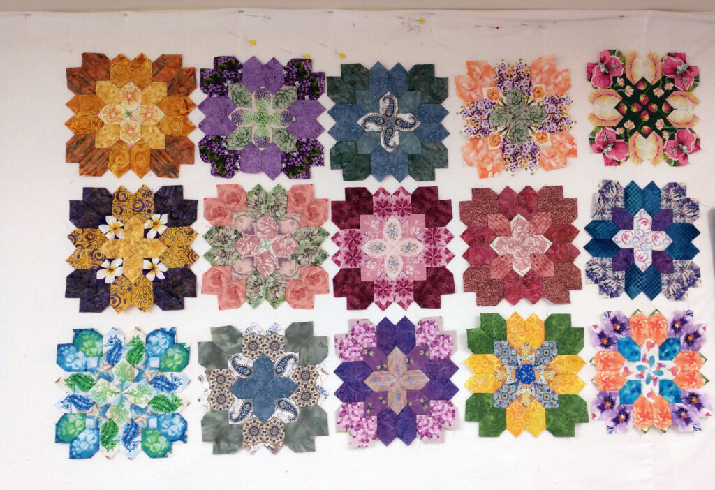 Pieced fabric hexagons arranged in a row for a quilt.