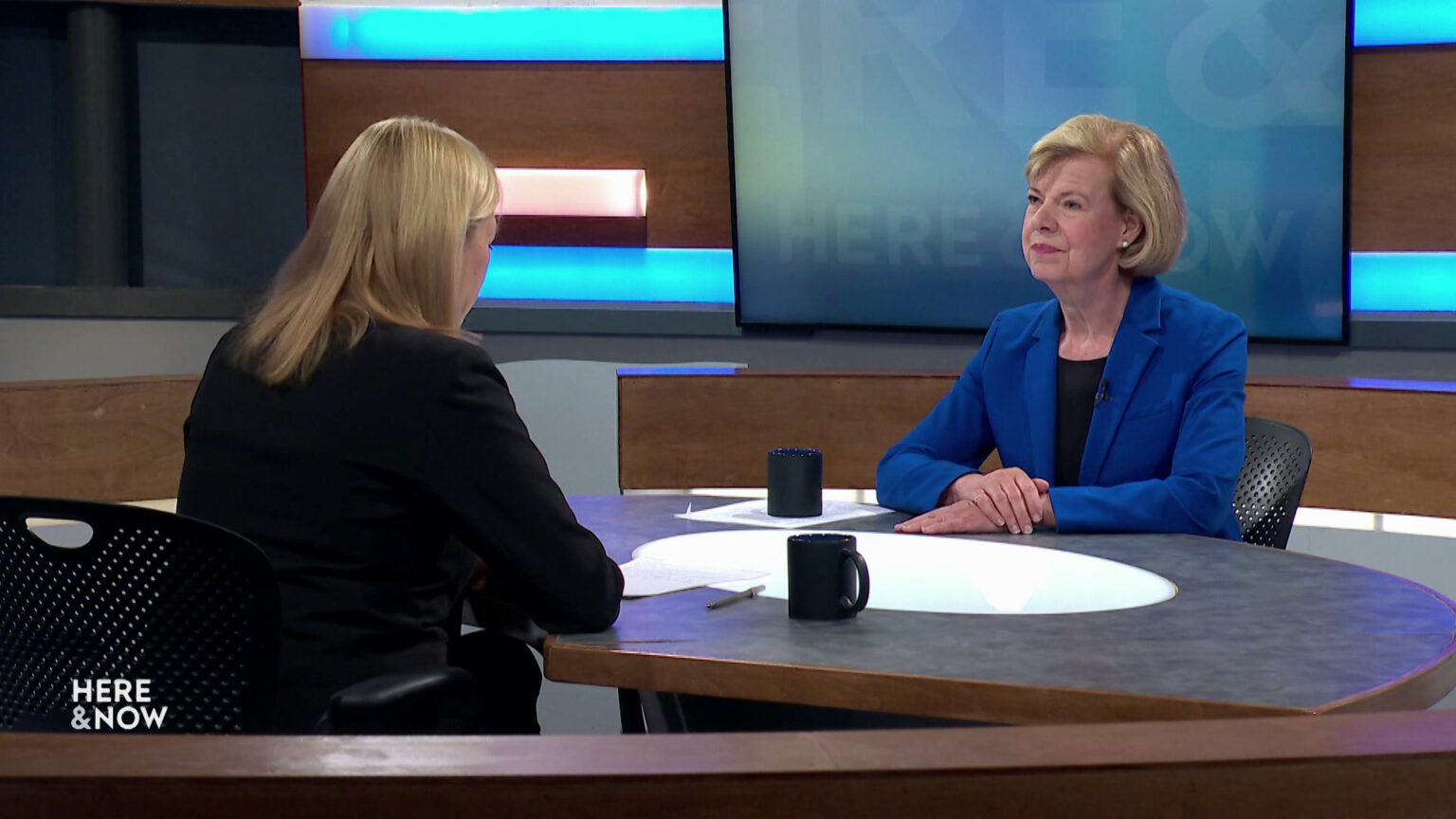 Frederica Freyberg and Tammy Baldwin sit facing each other on the Here & Now set.