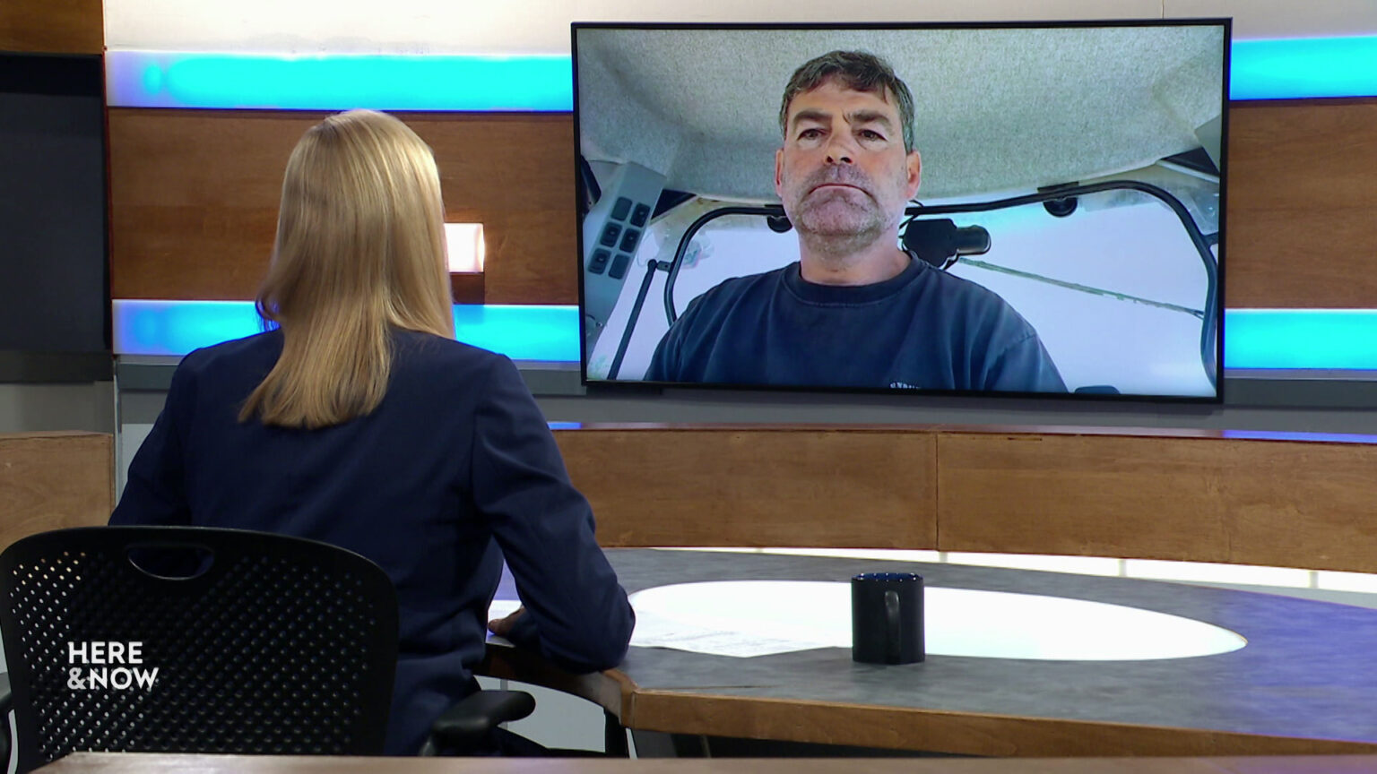 Frederica Freyberg sits at a desk on the Here & Now set and faces a video monitor showing an image of Tony Kurtz. Frederica Freyberg sits at a desk on the Here & Now set and faces a video monitor showing an image of Tony Kurtz.