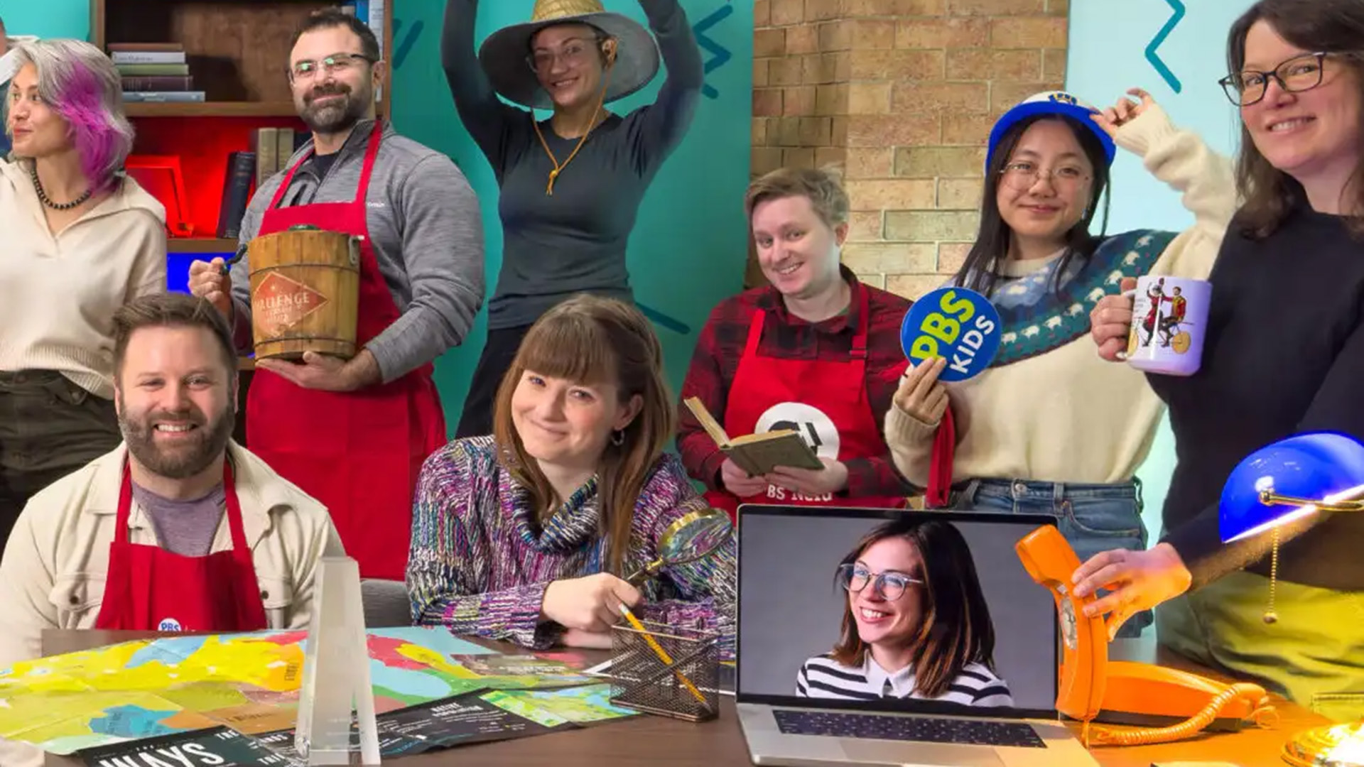 The PBS Wisconsin Education team poses playfully with props on the set of The Look Back. (Source: The Look Back | PBS Wisconsin.)