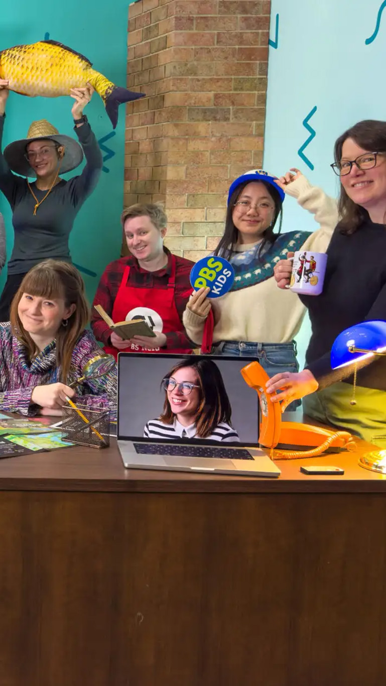 The PBS Wisconsin Education team poses playfully with props on the set of The Look Back. (Source: The Look Back | PBS Wisconsin.)